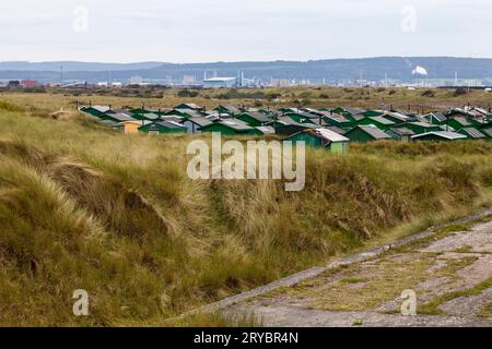 Les huttes de pêcheurs de couleur verte à South Gare, Redcar, Angleterre, Royaume-Uni avec les longues herbes au premier plan Banque D'Images