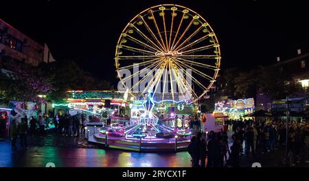 Brilon, Rhénanie du Nord Westphalie/Allemagne - 23 septembre 2023 : grande roue illuminée et carrousel pour enfants le soir à la foire de Brilon. Banque D'Images