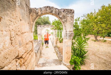 Vieux touriste dans la galerie des arches dans le jardin Banque D'Images