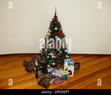 Minas Gerais, Brésil - 23 décembre 2022 : arbre de noël avec détails festifs et divers cadeaux emballés Banque D'Images