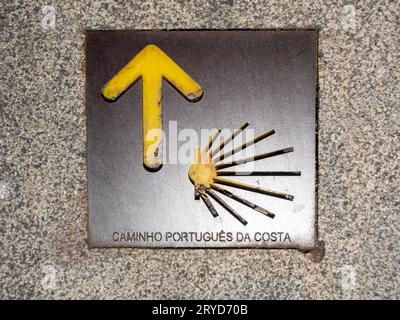 Une plaque métallique sur le trottoir dans la ville de Porto pointant vers la direction du Camino Portugues côtier menant à Santiago de Compostelle Banque D'Images
