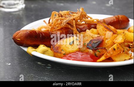 Close up partie des pommes de terre rôties avec saucisse Banque D'Images