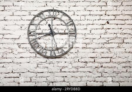 Vieille horloge en métal peint en blanc sur le mur de brique grunge Banque D'Images