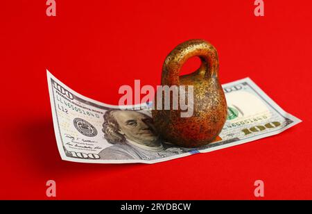 Billets en dollars US en vertu de poids sur fond rouge Banque D'Images