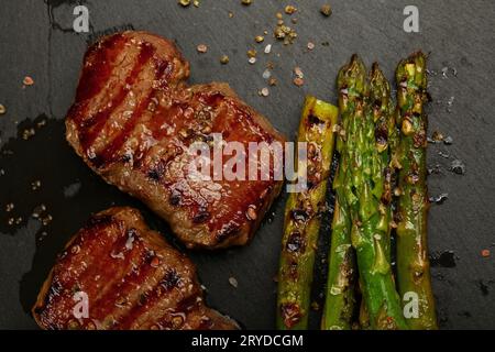 Close up boeuf grillé steaks sur plaque en ardoise noire Banque D'Images