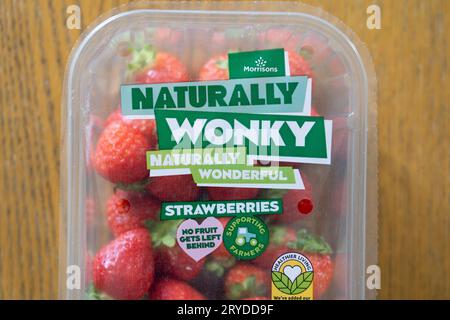 Fraises de marque propre de supermarché Morrisons en paquet, étiquetées comme naturellement Wonky. Concept : essayer de réduire le gaspillage alimentaire au Royaume-Uni, les fruits et légumes merveilleux Banque D'Images