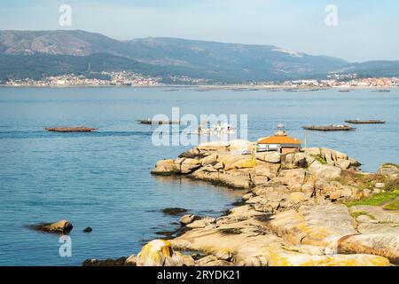 Paysage marin de Rias Baixas avec phare et bateau à moules Banque D'Images