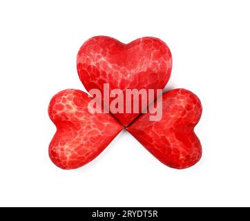 Trois coeurs sculptés en bois rouge isolés sur blanc Banque D'Images
