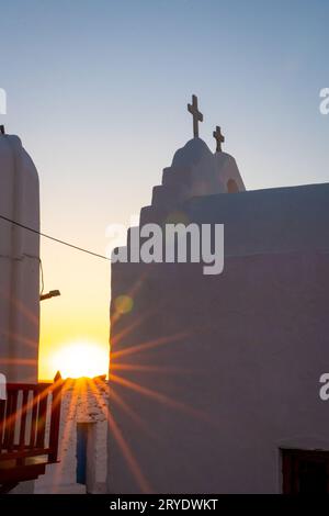 Rayons de soleil sur l'église Panagia Paraportiani au coucher du soleil Banque D'Images