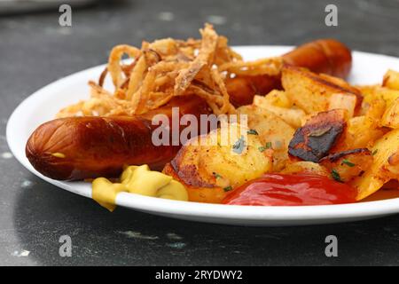 Close up partie des pommes de terre rôties avec saucisse Banque D'Images