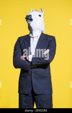 Homme avec masque de cheval sur fond jaune Banque D'Images