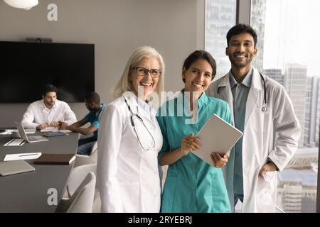 Joyeuse équipe de médecins plus jeunes et plus âgés réunis à la conférence Banque D'Images