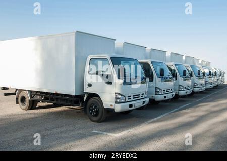 Les camions se tiennent dans le parking dans une rangée Banque D'Images