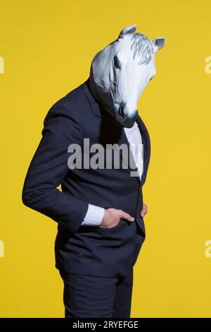 Homme avec masque de cheval sur fond jaune Banque D'Images