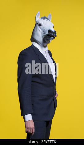 Homme avec masque de cheval sur fond jaune Banque D'Images