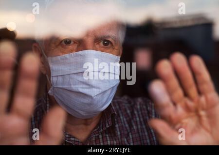 Homme caucasien âgé portant un masque facial protecteur fait à la main Banque D'Images