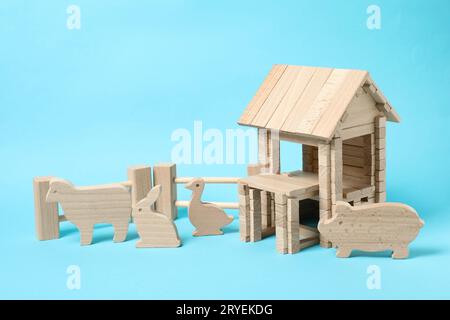 Maison en bois et animaux sur fond bleu clair. Jouet pour enfants Banque D'Images