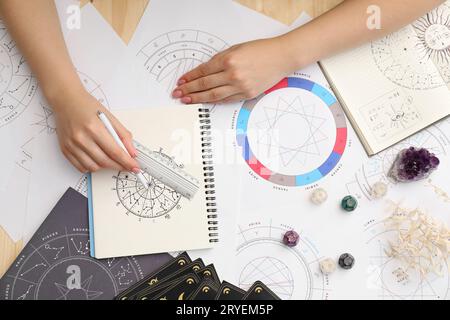 Astrologue utilisant la roue du zodiaque pour la prévision de destin à la table, vue de dessus. Dire la fortune Banque D'Images