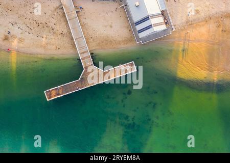 Vue aérienne d'une jetée en forme de T sur le bord d'une plage de sable à Barwon Heads à Victoria, Australie Banque D'Images