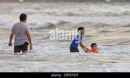 Kota Kinabalu, Sabah, Malaisie- 20 novembre 2021 : visiteur non identifié appréciant et heureux jouant belle et propre plage pendant le coucher du soleil Banque D'Images