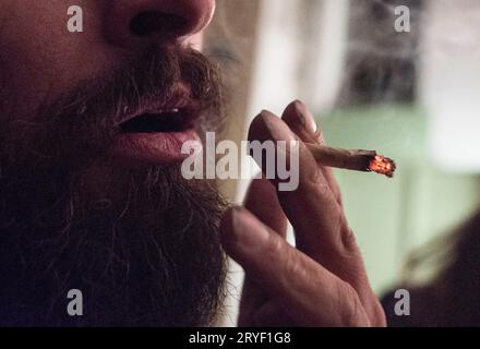 L'homme à la barbe fume une cigarette roulée Banque D'Images