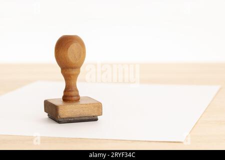 Timbre en caoutchouc vintage et papier vierge sur table en bois. Espace de copie Banque D'Images