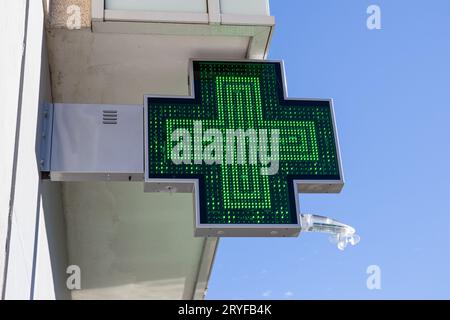 Panneau électrique de la pharmacie sur la façade du bâtiment.Croix verte éclairée Banque D'Images