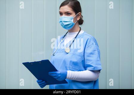 Portrait du jeune médecin devant un mur de verre bleu Banque D'Images