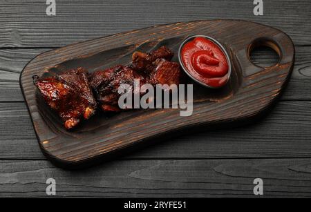 Côtes de rechange au barbecue et sauce barbecue sur bois Banque D'Images