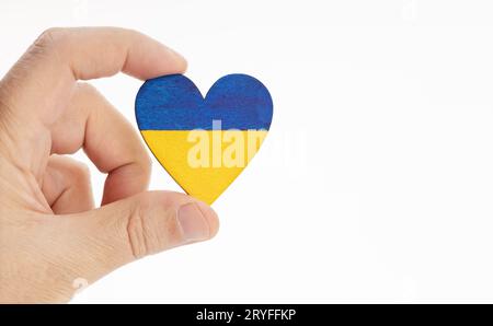 Main tenant un drapeau de l'Ukraine sur la forme de coeur. Arrière-plan blanc. Copier l'espace Banque D'Images