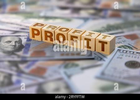 Texte de profit écrit sur des blocs de bois avec des billets de banque américains sur le fond Banque D'Images