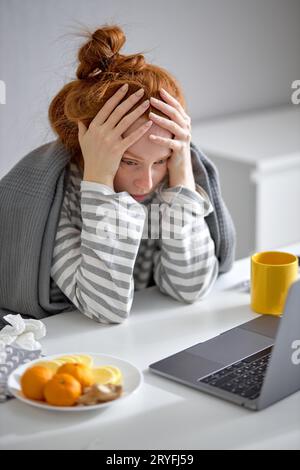 triste frustré étudiant féminin touchant sa tête, en utilisant un ordinateur portable, a des problèmes avec l'étude en ligne, l'éducation difficile, gros plan portrait vue de côté Banque D'Images