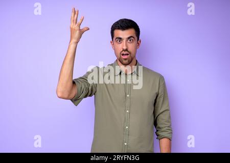 choqué surpris homme barbu avec le bras levé exprimant ses émotions de sentiment gros plan portrait isolé fond bleu plan studio Banque D'Images