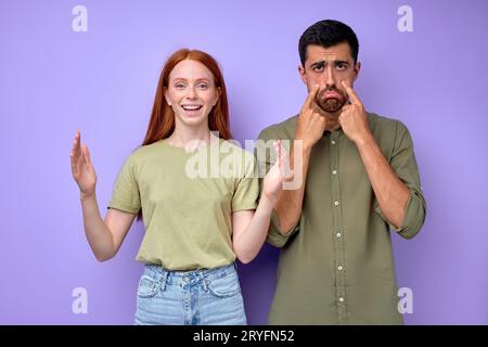 joyeuse fille sourde rousse et malheureuse sourde triste homme sourd, gros plan portrait isolé fond bleu. Banque D'Images