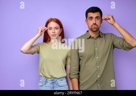 Jeune couple sourd et muet avec des gestes de mains disant portrait intelligent en gros plan isolé bleu Banque D'Images