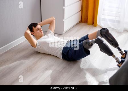 Homme handicapé amputé. Jeune homme caucasien avec entraînement de prothèse de jambe à la maison, faisant de l'entraînement. positivité corporelle et concept d'estime de soi. Désactivé Banque D'Images