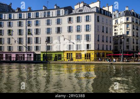 FRANCE. PARIS (75) QUARTIER XEME. CANAL SAINT-MARTIN. LES BÂTIMENTS DU QUAI DE VALMY ET LES FAÇADES COLORÉES DES MAGASINS ANTOINE ET LILI Banque D'Images