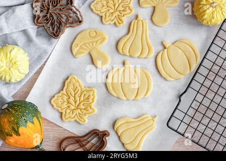 Préparation de biscuits festifs pour la cuisson au four. Biscuits prêts à cuire en forme de feuilles d'automne et de citrouilles. Banque D'Images