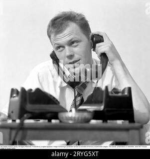 Dans les années 1950 Sixten Larsson avec deux téléphones semble occupé et semble parler dans deux combinés en même temps, un contre chaque oreille. Suède 1952. Conard réf. 2020 Banque D'Images