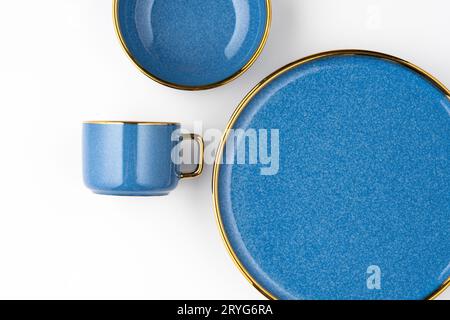 Un ensemble d'assiettes en céramique bleue et une tasse sur un fond blanc. Vue de dessus Banque D'Images
