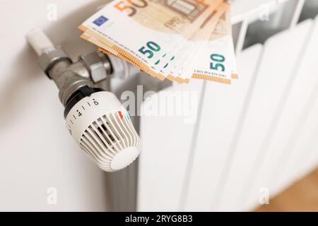 Gros plan des billets en euros sur un radiateur de chauffage. Concept de crise du coût de l'énergie Banque D'Images