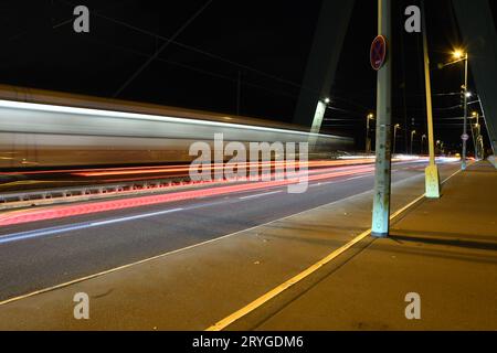 Traces légères de voitures sur le pont Severin la nuit à Cologne, Allemagne, longue exposition Banque D'Images