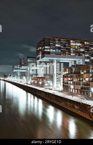 Vue aérienne des grues illuminées au bord du canal du Zollhafen à Cologne, en Allemagne, la nuit Banque D'Images