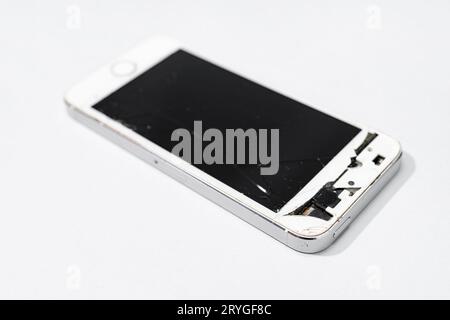 Smartphone avec écran cassé isolé sur fond gris. Téléphone portable endommagé Banque D'Images