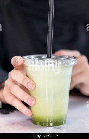 Cocktail de citron frais et de menthe dans les mains des femmes, closeup. Mode de vie sain. Banque D'Images