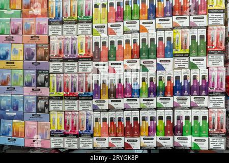 Emballage jetable de vapes aux couleurs vives et aromatisées exposé dans une vitrine Banque D'Images