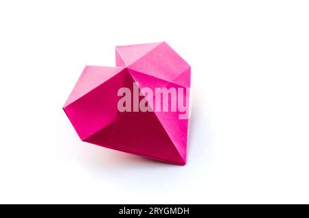 Coeur de papier rose origami isolé sur fond blanc Banque D'Images