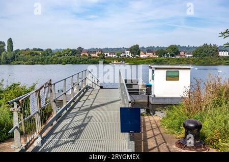 Plate-forme métallique au petit quai de ferry sur la rivière Maas, frontière entre la Hollande et la Belgique, village belge Lanaye et arbres feuillus en arrière-plan, ensoleillé et Banque D'Images