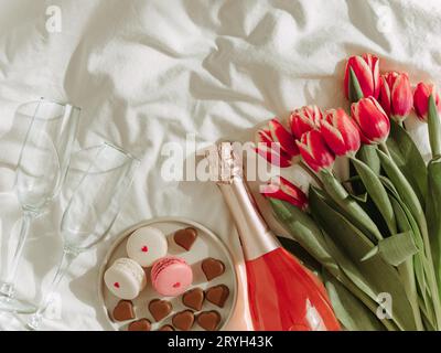 Bouquet de tulipe rouge et de vin rose sur les draps Banque D'Images