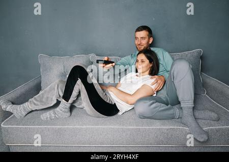 Jeune couple regardant la TV à la maison Banque D'Images